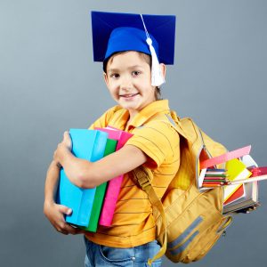 Portrait of happy schoolkid with backpack and books