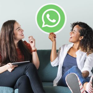 Young women showing a WhatsApp Messenger icon